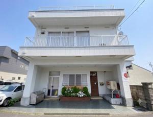 a white house with a balcony on top of it at ParkView SAKURA in Aomori