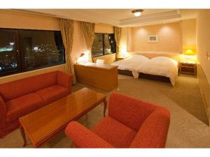 Grand Plaza Nakatsu Hotel في Nakatsu: غرفة فندقية بسرير وطاولة وكراسي