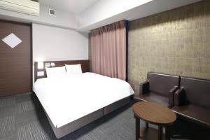 a hotel room with a bed and a table at Dormy Inn Premium Namba Natural Hot Spring in Osaka +105 photos