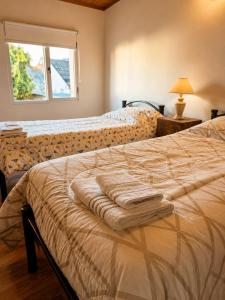 a bedroom with a bed with a blanket on it at El Refugio de la Trochita in Esquel