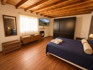 a bedroom with a blue bed and wooden floors at El Refugio de la Trochita in Esquel