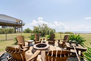 a patio with chairs and a table and a fire pit at Beachfront Fire Pit Gourmet Kitchen Views in Bolivar Peninsula