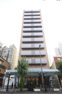 東京にあるR&Bホテル蒲田東口の目の前を歩く人々のいる高い建物