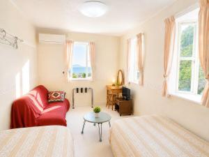 a bedroom with a bed and a couch and a table at Villa Knossos in Higashiizu