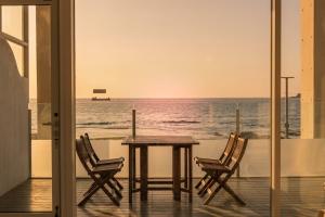 a table and chairs on a balcony with the ocean at Vinolian Ocean View Spa Pension in Goseong