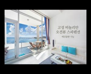 a living room with a view of the ocean at Vinolian Ocean View Spa Pension in Goseong