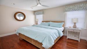 a bedroom with a bed with a blue comforter and a mirror at Welahpu Beach in Cape May +32 photos