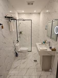 a bathroom with a shower and a toilet and a sink at فندق الضيافة in Abu Arish