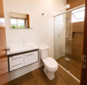 a bathroom with a toilet and a sink and a shower at Sobrado do Papagaio in Palhoça +6 photos