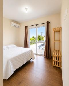 a bedroom with a bed and a sliding glass door at Sobrado do Papagaio in Palhoça