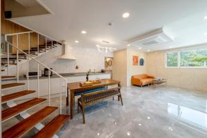 a living room with a staircase and a table at Chuncheon DBJ in Chuncheon