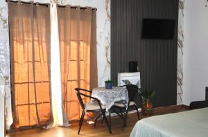 a table and chairs in a room with a window at The Cozy Beach Studio in San Juan