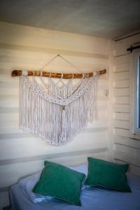 a curtain hanging over a bed with two green pillows at Tribu Hostal in El Paredón Buena Vista +72 photos