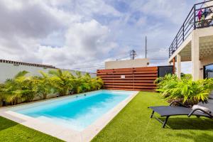 a swimming pool in a yard next to a building at Esensia Boutique Studio in Oranjestad