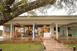 a building with a deck and a tree at Éden jardim in Guarapuava