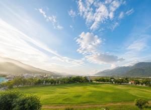 a green field with a city and mountains in the background at 雀居民宿 in Yuli