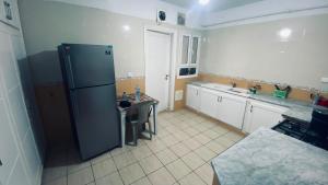 a kitchen with a refrigerator and a table in it at Casa Cómoda in Nabeul