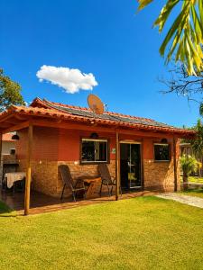 a house with a deck with a table and chairs at Chalés Araras do Vale in Colinas Do Sul