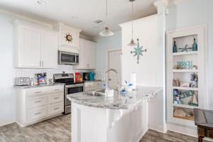 a kitchen with white cabinets and a granite counter top at Gulf Views Steps to Beach 2 King Beds 3Bd 2Bth in Bolivar Peninsula