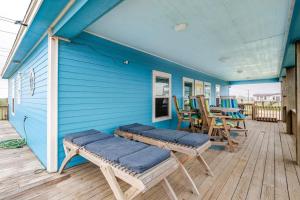 a blue house with chairs and a table on a deck at Gulf Views Steps to Beach 2 King Beds 3Bd 2Bth in Bolivar Peninsula
