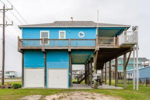 a blue house with a deck and two garage doors at Gulf Views Steps to Beach 2 King Beds 3Bd 2Bth in Bolivar Peninsula +48 photos