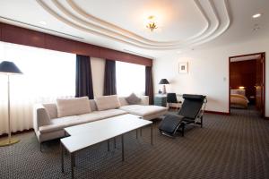 a living room with a couch and a table at Hotel Granmirage in Uozu