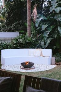 a fire burns in a bowl on a table at Moso House Pearl Beach in Pearl Beach