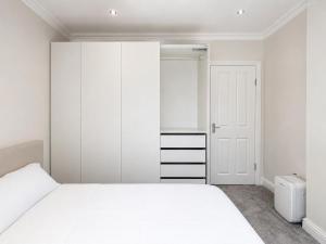 a bedroom with a white bed and a closet at Full House - Croydon centre in Croydon