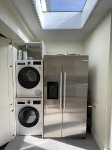 a kitchen with a refrigerator and a washer and dryer at Full House - Croydon centre in Croydon +3 photos