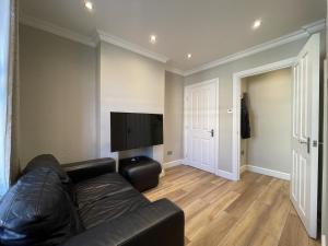 a living room with a couch and a flat screen tv at Full House - Croydon centre in Croydon