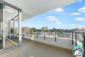 a large balcony with large windows and a view of the city at Asquith 2BR Apt Secure Underground Parking in Asquith