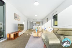 a living room with a couch and a tv at Asquith 2BR Apt Secure Underground Parking in Asquith +6 photos