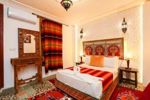 a bedroom with a large bed and a fireplace at Dar Houda in Fez