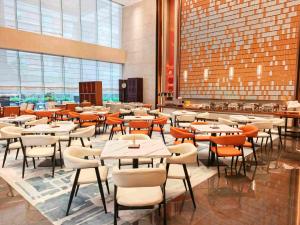 a restaurant with tables and chairs in a building at Landmark International Hotel - Grandview Mall in Guangzhou