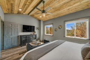 a bedroom with a large bed and a flat screen tv at Sandstone Pointe, Elegance Among the Cliffs in Mount Carmel