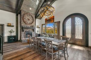 a dining room with a table and chairs and a fireplace at Sandstone Pointe, Elegance Among the Cliffs in Mount Carmel