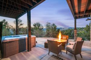 a patio with a fireplace and a hot tub at Sandstone Pointe, Elegance Among the Cliffs in Mount Carmel