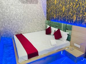 a small bed with red and white pillows in a room at Hotel Maatrika and banquets in Orchha
