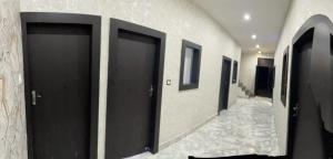 a row of black doors in a hallway at Hotel Maatrika and banquets in Orchha