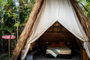 a bed in a tent in the woods at Tribu Hostal in El Paredón Buena Vista