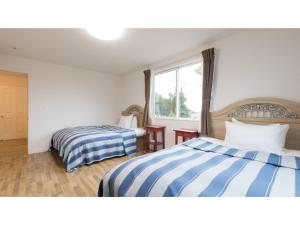 a hotel room with two beds and a window at TEA TREES - Vacation STAY 86532v in Tateyama