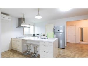 a kitchen with white cabinets and a stainless steel refrigerator at TEA TREES - Vacation STAY 86532v in Tateyama