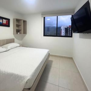 a bedroom with a bed and a flat screen tv at Hotel Zona Oro in Armenia