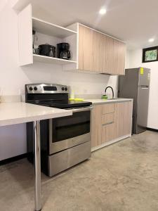 a kitchen with a stove and a refrigerator at Apartamentos Aledu in Brasilito