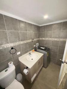 a bathroom with a white toilet and a sink at Apartamentos Aledu in Brasilito