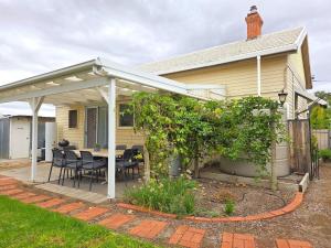 a house with a patio with a table and chairs at Cosy Cottage in Port Broughton