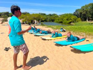 a group of children laying on surfboards on a beach at Saha surf camp lesson booking only in Pottuvil