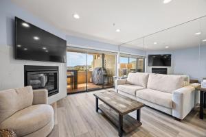 a living room with two couches and a fireplace at Seascape Ocean View Condo in Aptos
