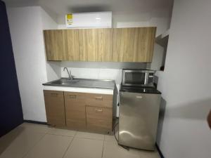 a small kitchen with a sink and a refrigerator at Hotel Boutique Santa Ana in Cartago