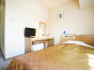 a hotel room with a bed and a television at Hotel Trend Nagano in Nagano